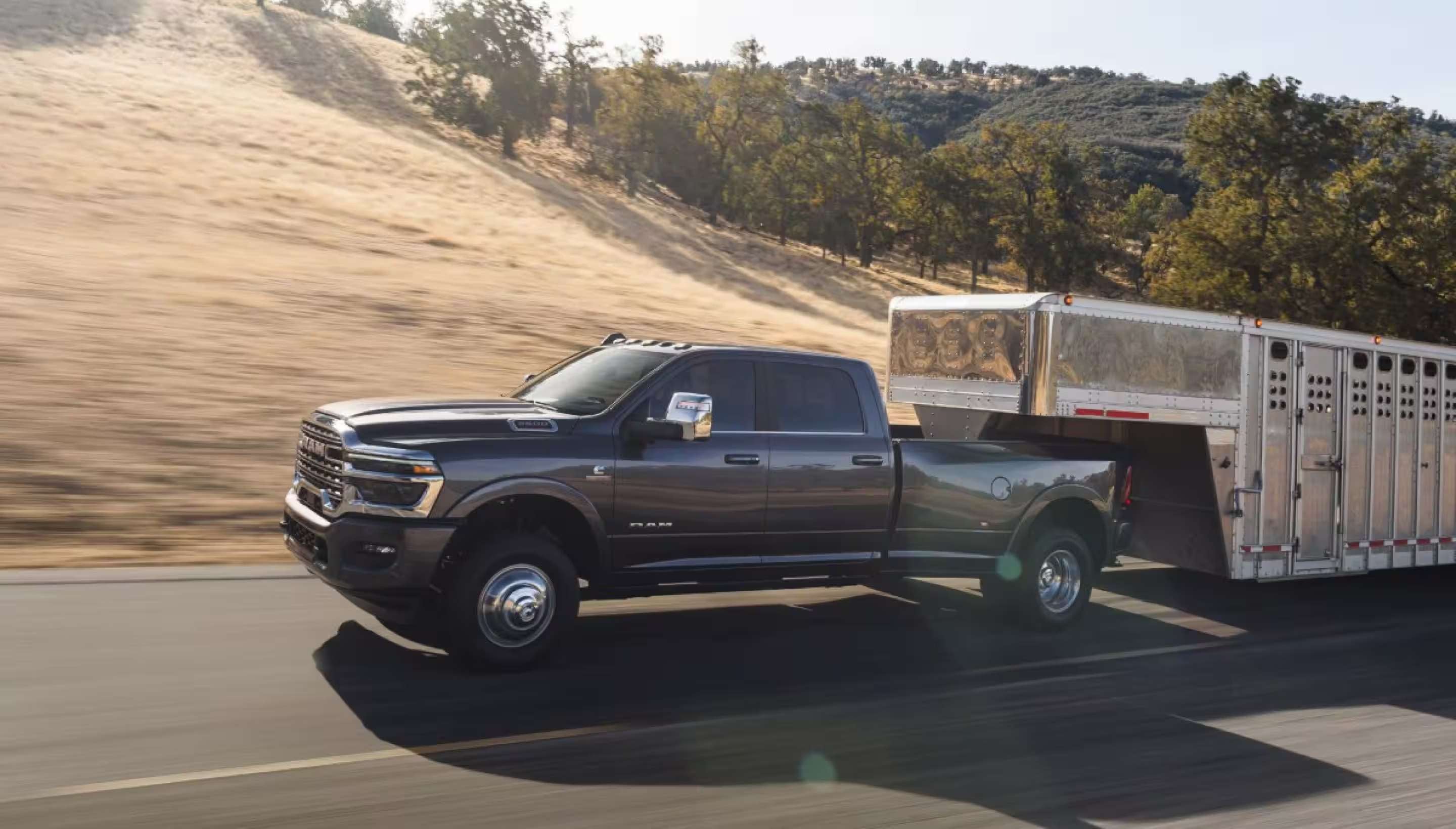 A RAM 3500 pulling a gooseneck horse trailer on a road.