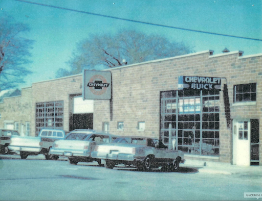 Vintage photo of classic cars outside the early Chevrolet dealership building